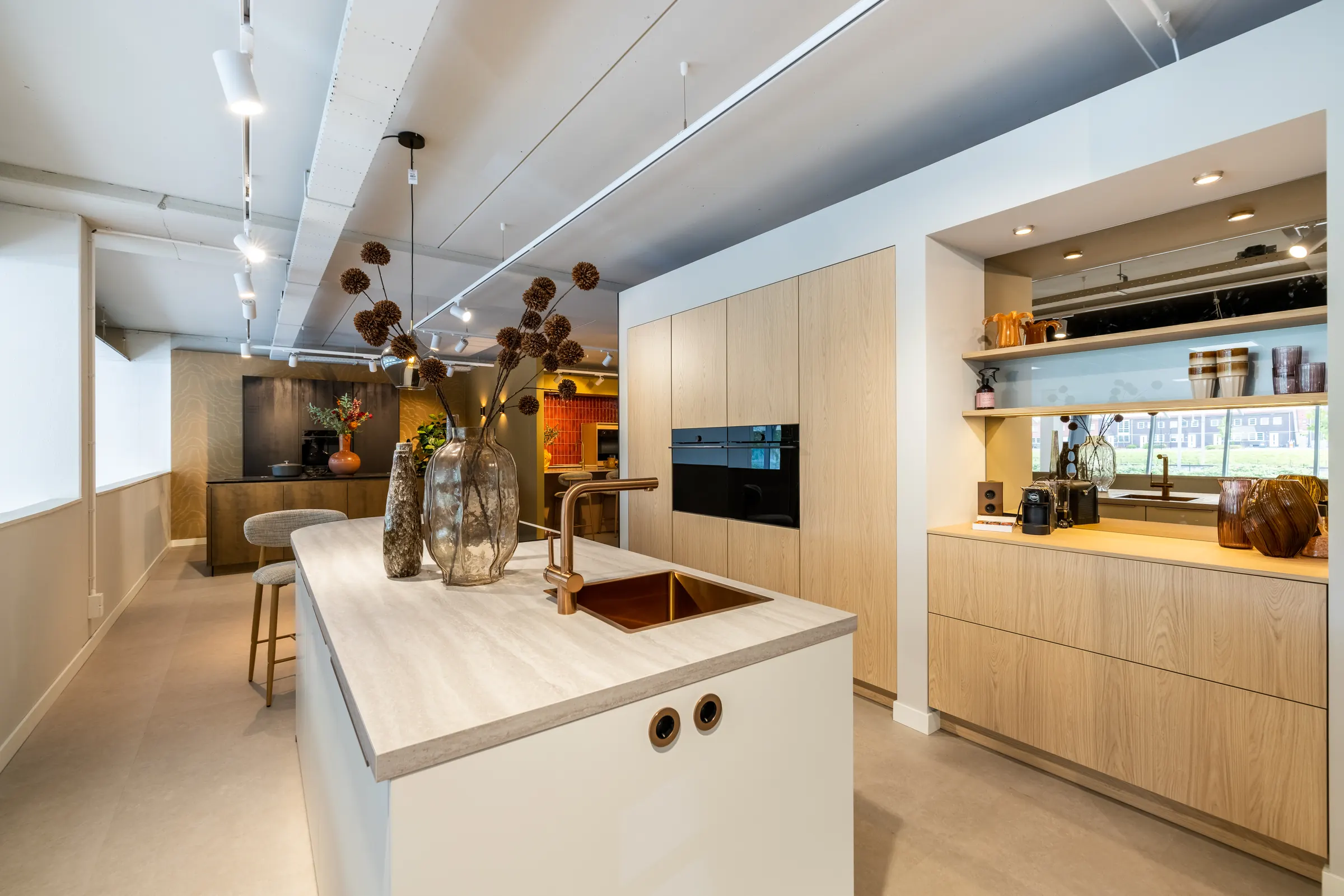 Kitchen4All-showroom met een kookeiland in licht hout
