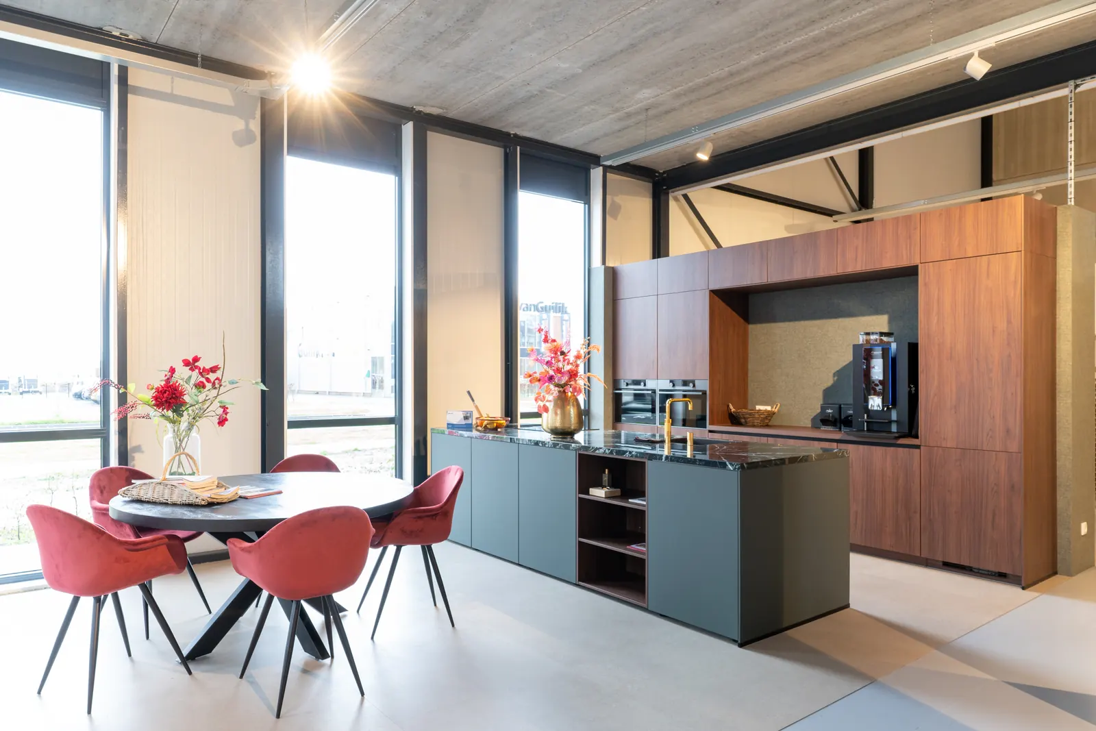 Keuken met eiland en rode stoelen bij de ramen in de Kitchen4All-showroom in Hattemerbroek
