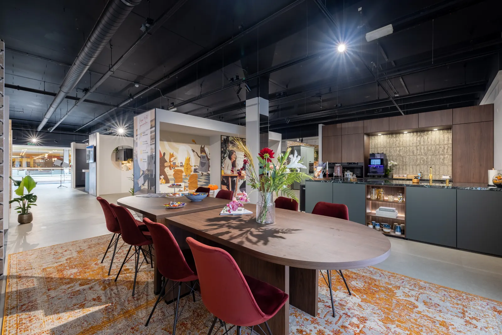 Kitchen4All-showroom in Rotterdam met lange eettafel en rode stoelen