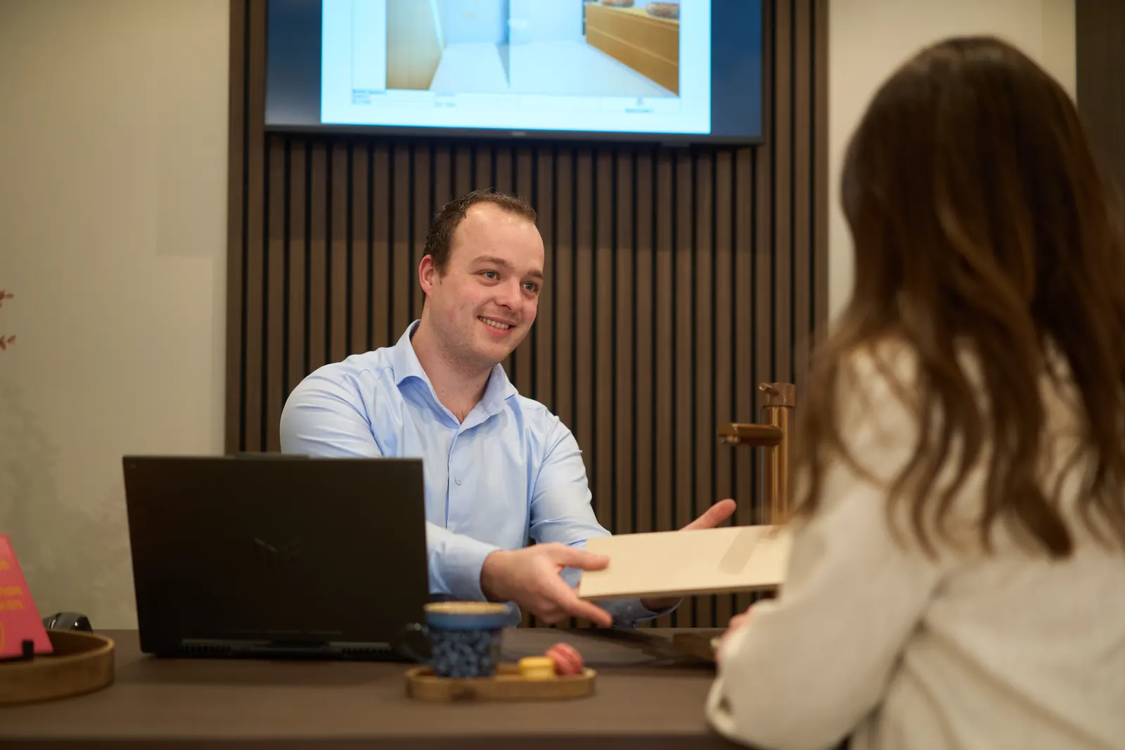 Coen van Sani4All Apeldoorn laat een klant een tegel zien aan de ontwerptafel