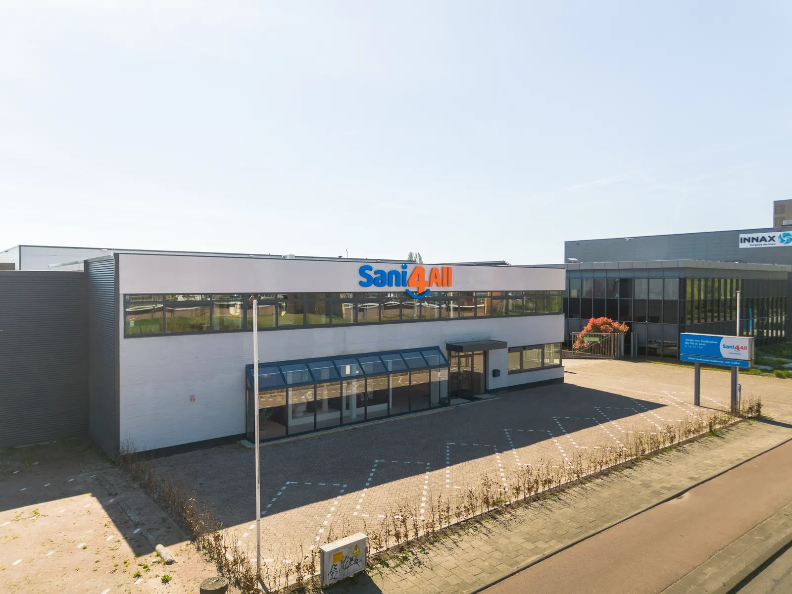 Dronefoto van de gevel van Sani4All Veenendaal met parkeerterrein