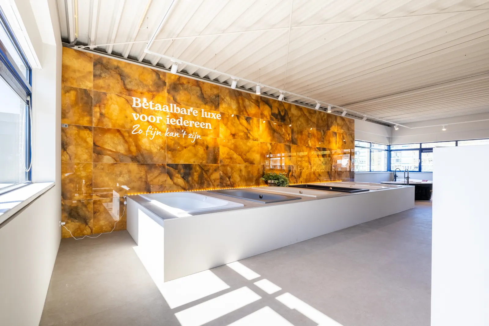 Sani4All-showroom in Veenendaal met gouden wand 'Betaalbare luxe voor iedereen' en badenopstelling